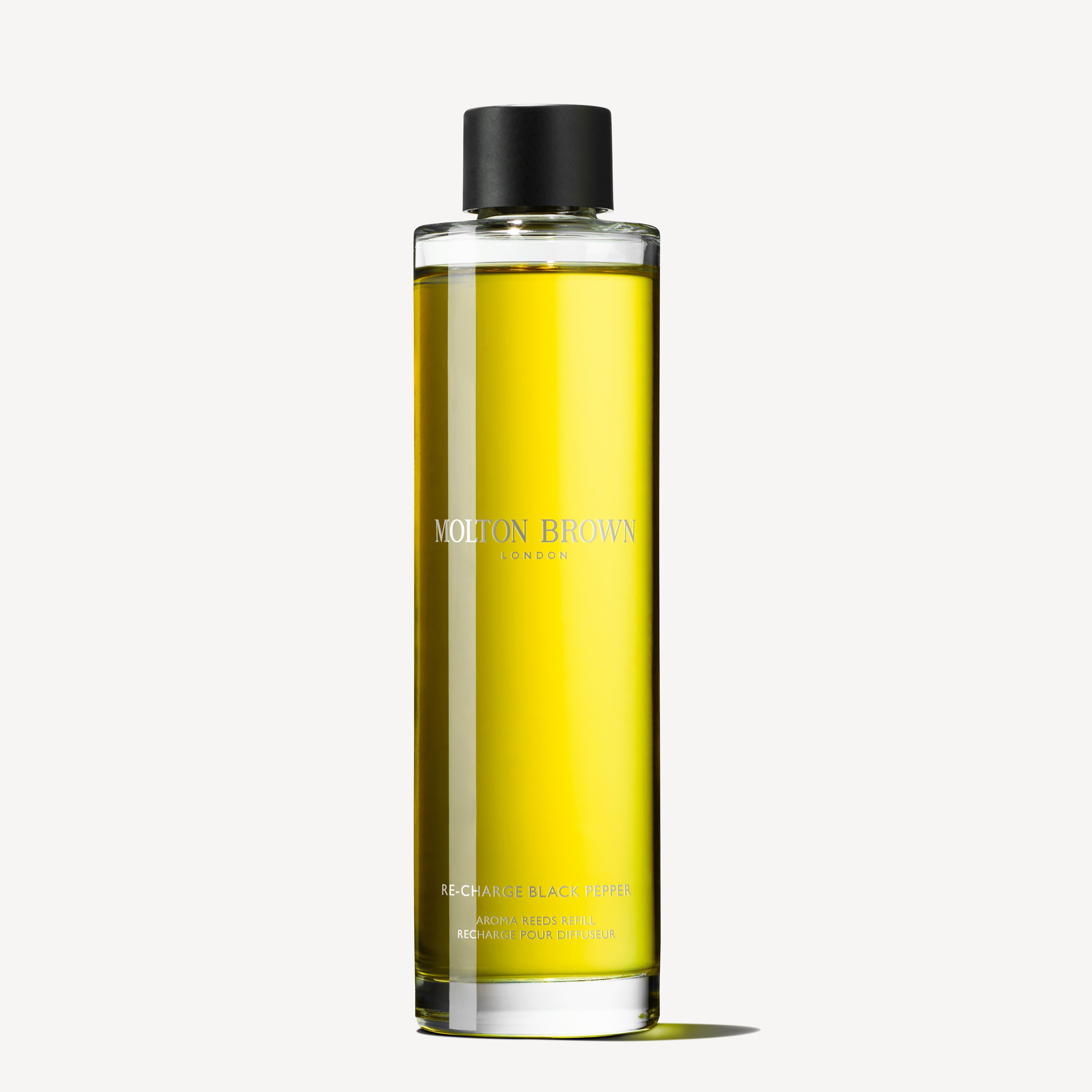 A bottle of MoltonBrown Cyprus Re-charge Black Pepper Aroma Reeds Refill 150ml is elegantly displayed against a plain white background, showcasing the yellow liquid with a black cap and minimalist label, exuding spicy, earthy tones with hints of woody-citrus allure.