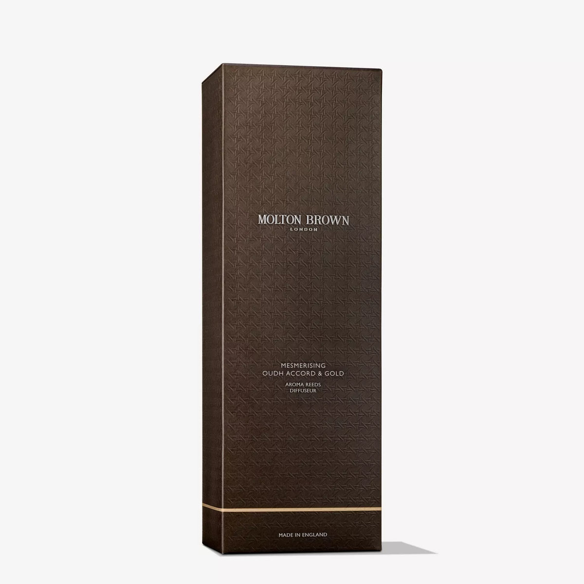A tall, dark brown box with a gold-accented design labeled Mesmerising Oudh Accord & Gold Aroma Reeds 150ml by MoltonBrown Cyprus offers a touch of scented decadence.