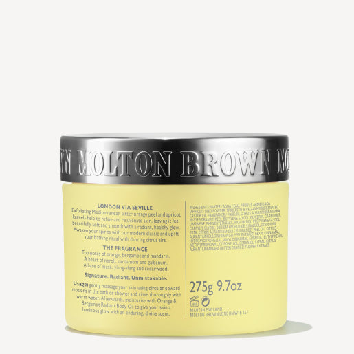 A tub of MoltonBrown Cyprus Orange & Bergamot Radiant Body Polisher with a metallic lid. The label includes product information, indicating the weight of 275g. The yellow packaging exudes citrus notes, complemented by brand detailing on the lid.