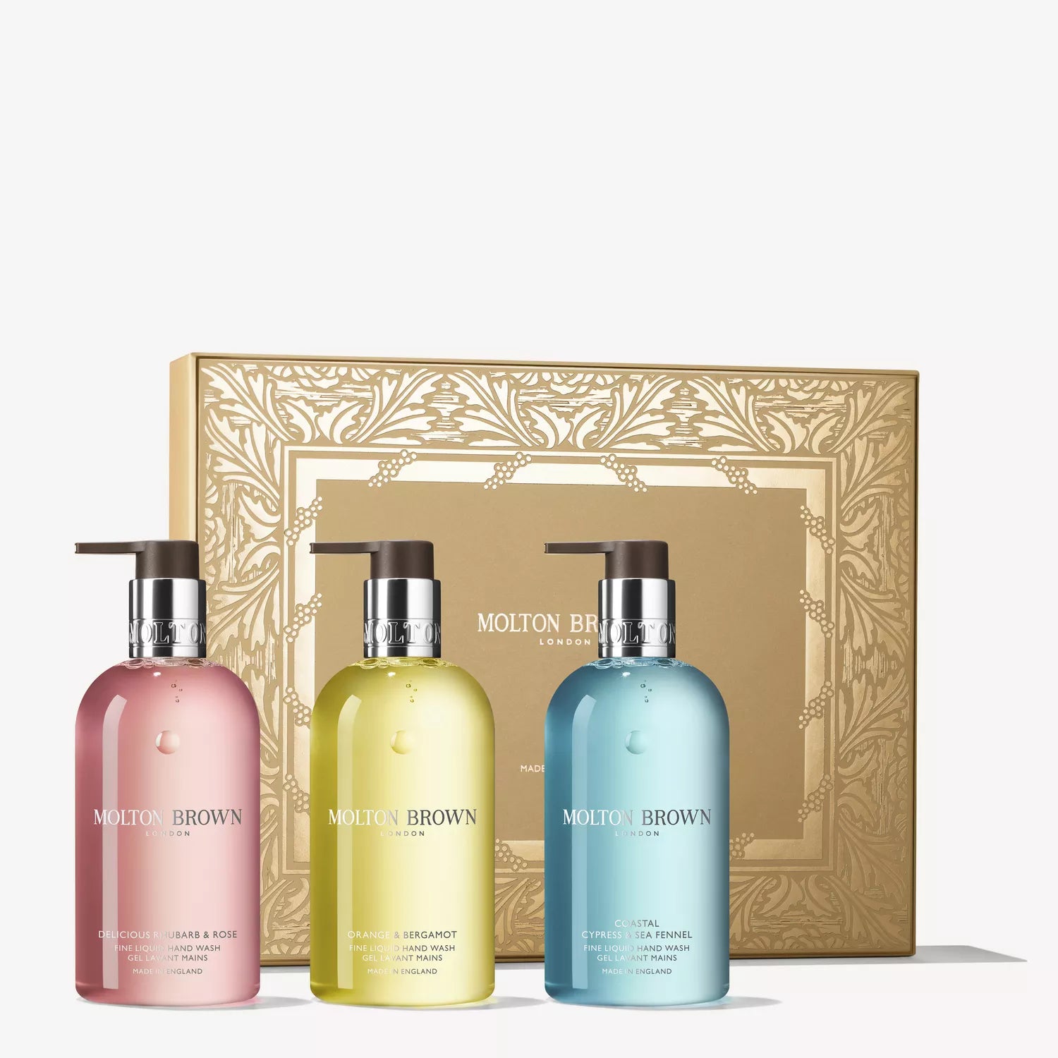 The Floral & Fresh Hand Care Collection by MoltonBrown Cyprus features three colorful liquid hand wash bottles displayed in front of an ornate gold gift box with a decorative pattern, offering lasting fragrance and elegant presentation.