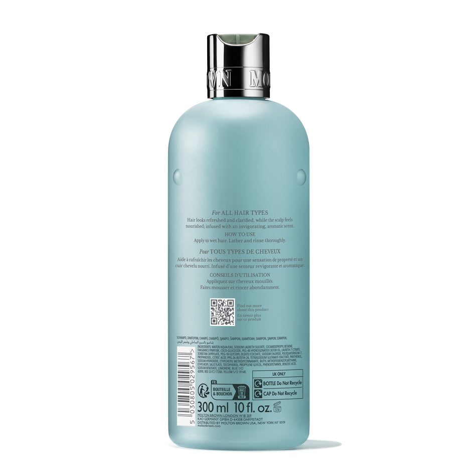 A 300ml blue MoltonBrown Cyprus Coastal Cypress & Sea Fennel Shampoo bottle with a silver cap, shown from the back. The label features instructions and details in several languages. Subtle marine notes evoke a refreshing coastal ambiance.