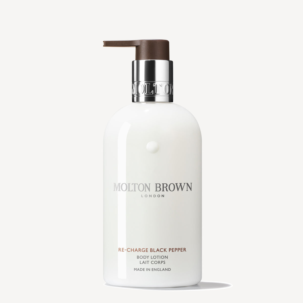 A 300ml bottle of Re-charge Black Pepper Body Lotion by MoltonBrown Cyprus, enriched with vetiver for an invigorating aroma. It includes a pump dispenser and a sleek design, prominently featuring the brand and product details on the label, crafted in England against a plain background.