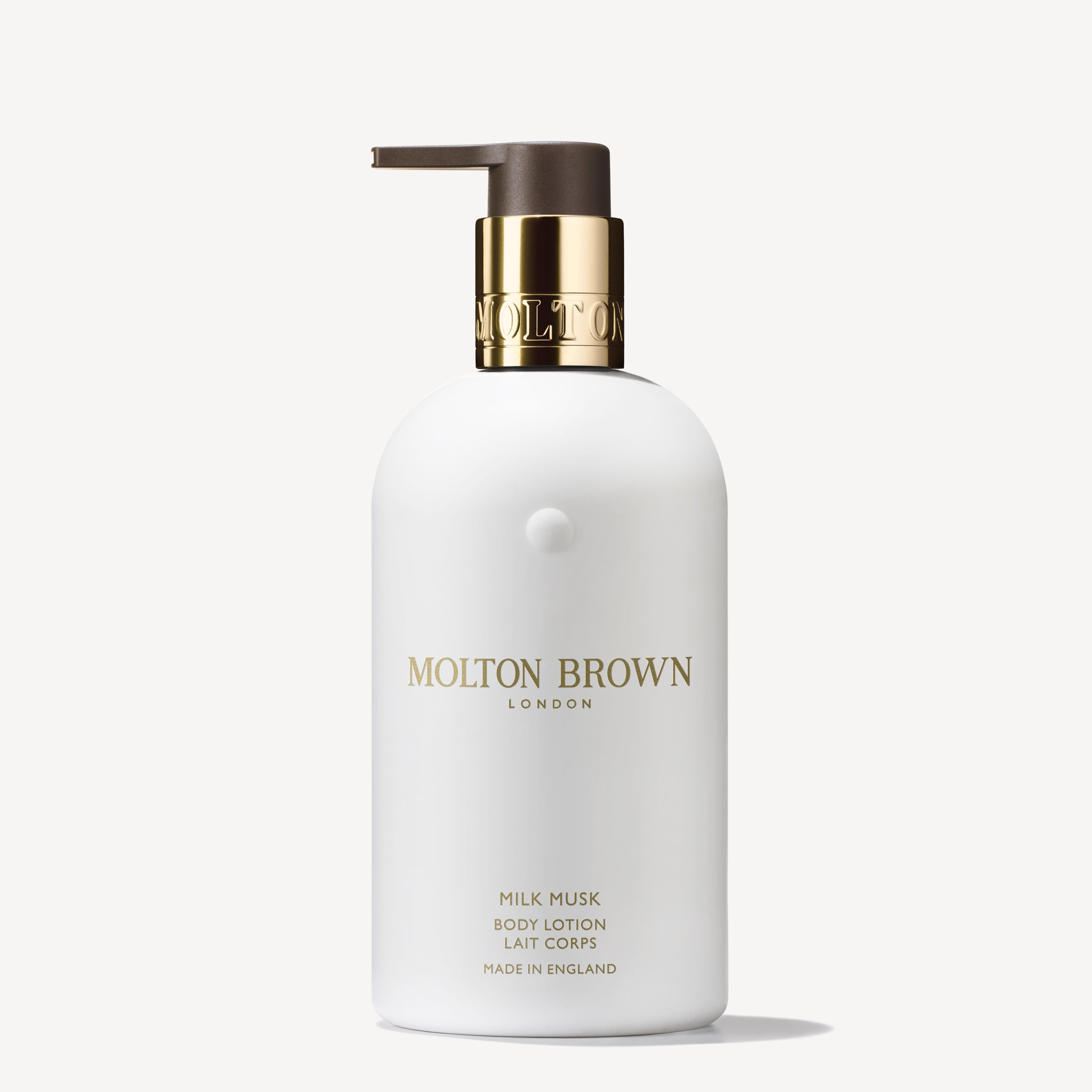 The Milk Musk Body Lotion 300ml from MoltonBrown Cyprus features soothing milk and creamy musk in a sleek white bottle with a pump dispenser and silver accents. The elegant font on the label highlights the brand name and product details, adding a touch of luxury.