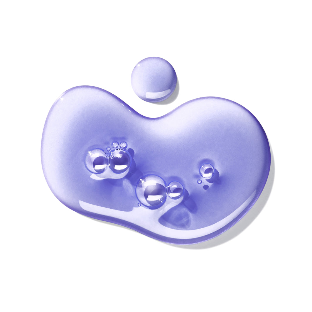 A white background showcases a purple translucent drop, with air bubbles evoking the Bluebell & Wild Strawberry Bath & Shower Gel by MoltonBrown Cyprus. Its irregular shape suggests the invigorating freshness of a spring woodland.