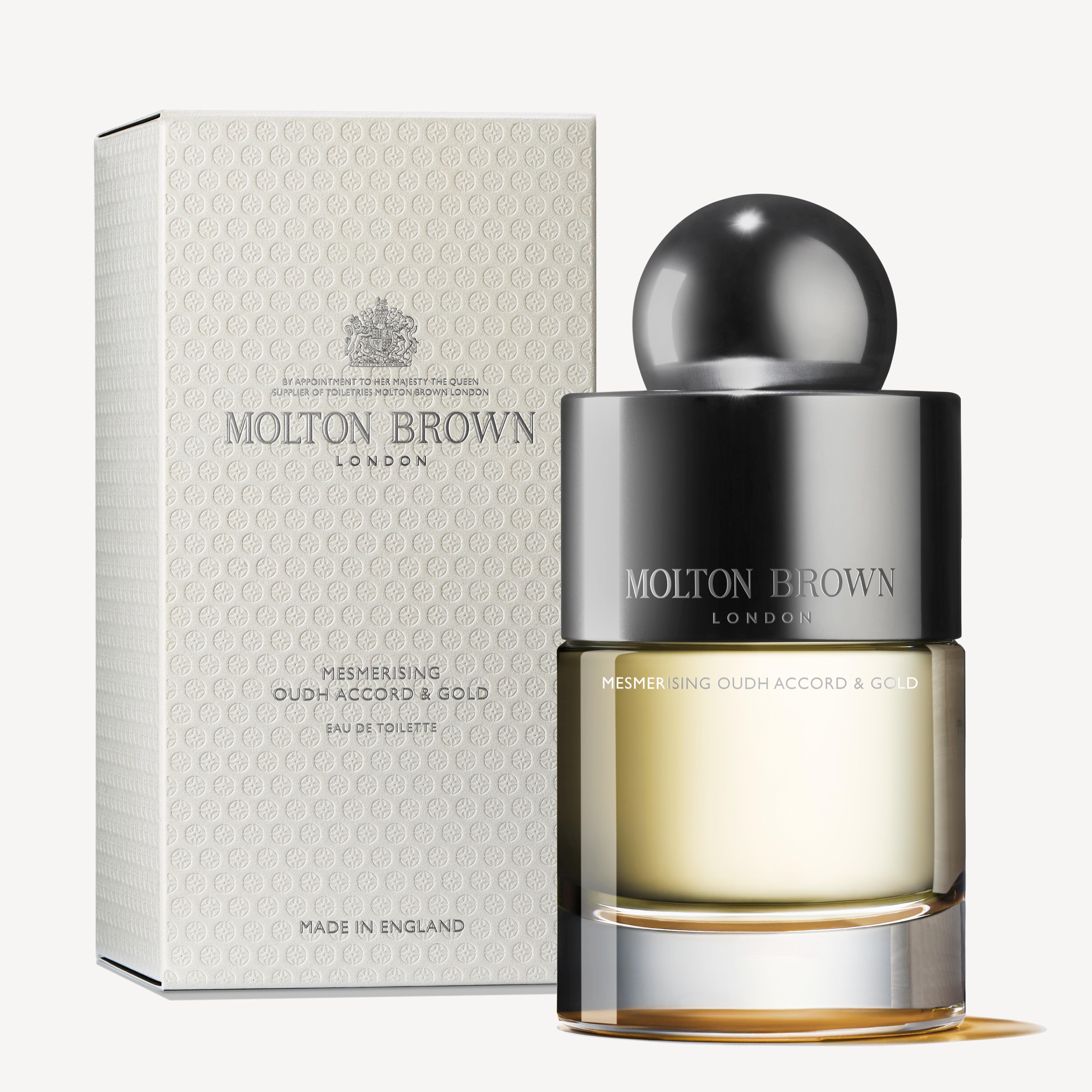 A bottle of MoltonBrown Cyprus Mesmerising Oudh Accord & Gold Eau de Toilette 100ml, featuring a rounded black cap, is placed in front of its matching box adorned with a textured pattern along with identical branding and product details.