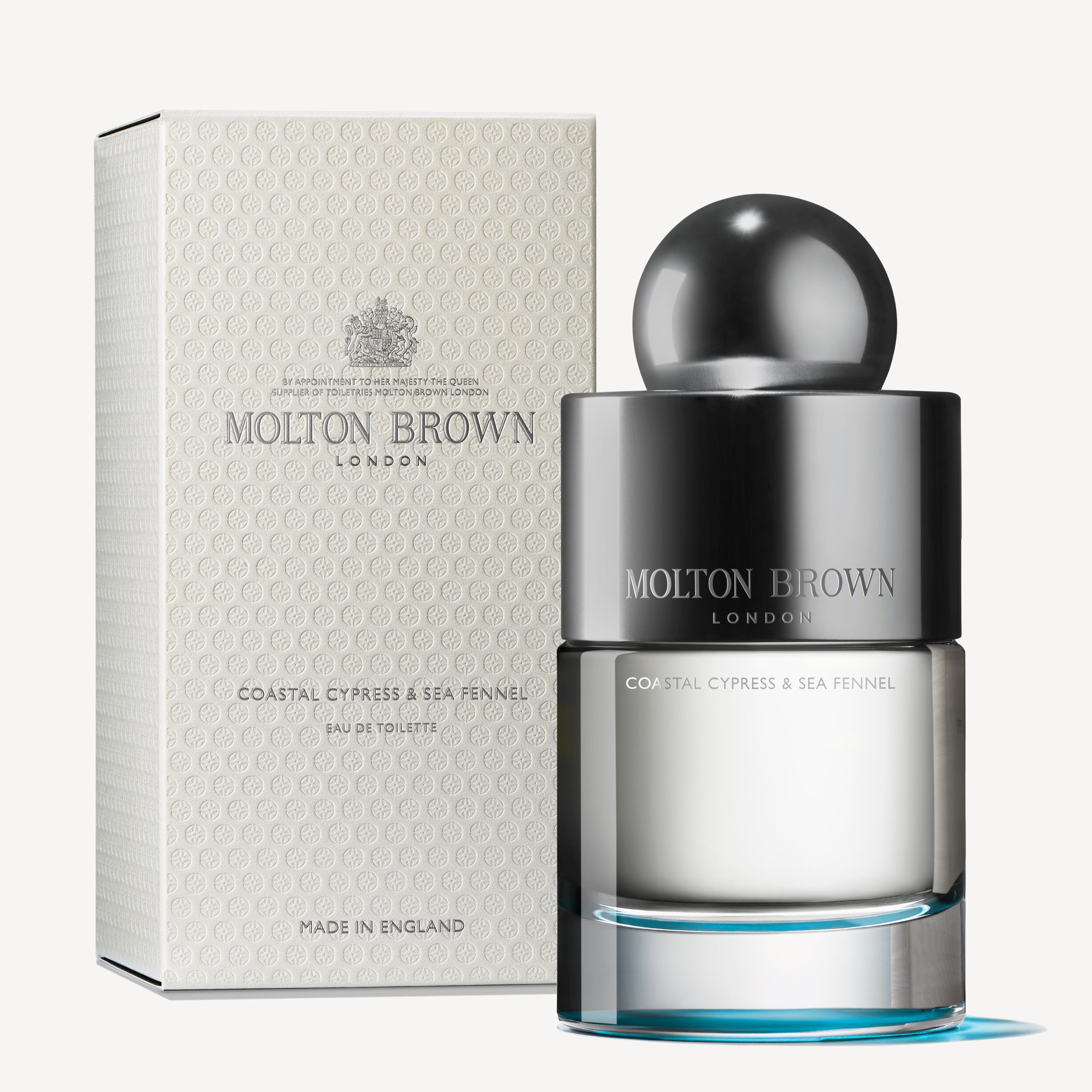 A MoltonBrown Cyprus Coastal Cypress & Sea Fennel Eau de Toilette 100ml bottle is displayed in front of its textured white and gray box. The bottle, featuring a shiny silver cap and a gradient glass design, evokes hints of cedarwood. The packaging has "Made in England" printed on it.