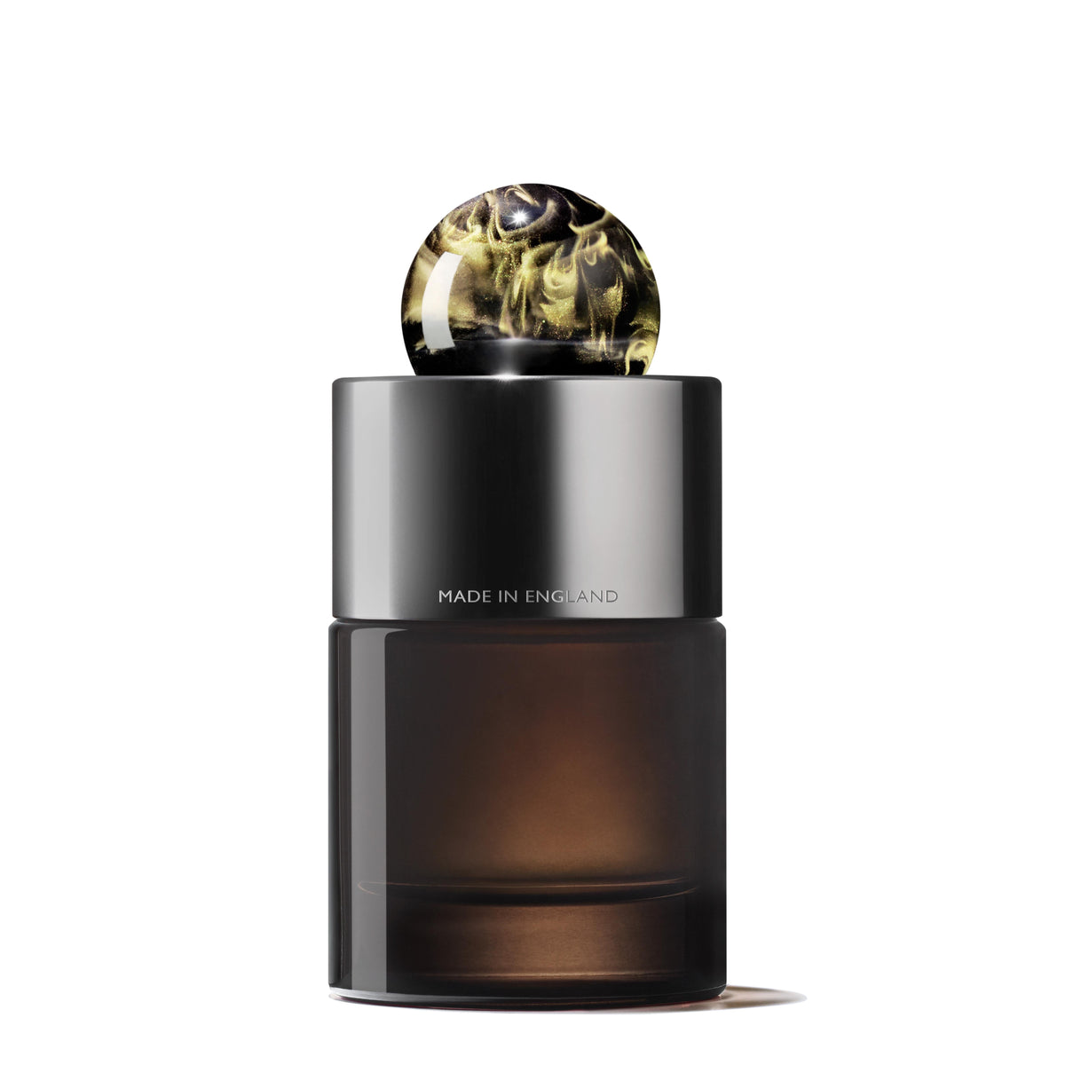 The Labdanum Dusk Eau de Parfum by MoltonBrown Cyprus features a sleek 100ml bottle with a dark, translucent body and a black cylindrical cap adorned with an elegant marbled pattern in shades of white and black, hinting at the rare oudh essence inside. "Made in England" is elegantly inscribed on the bottle's surface.
