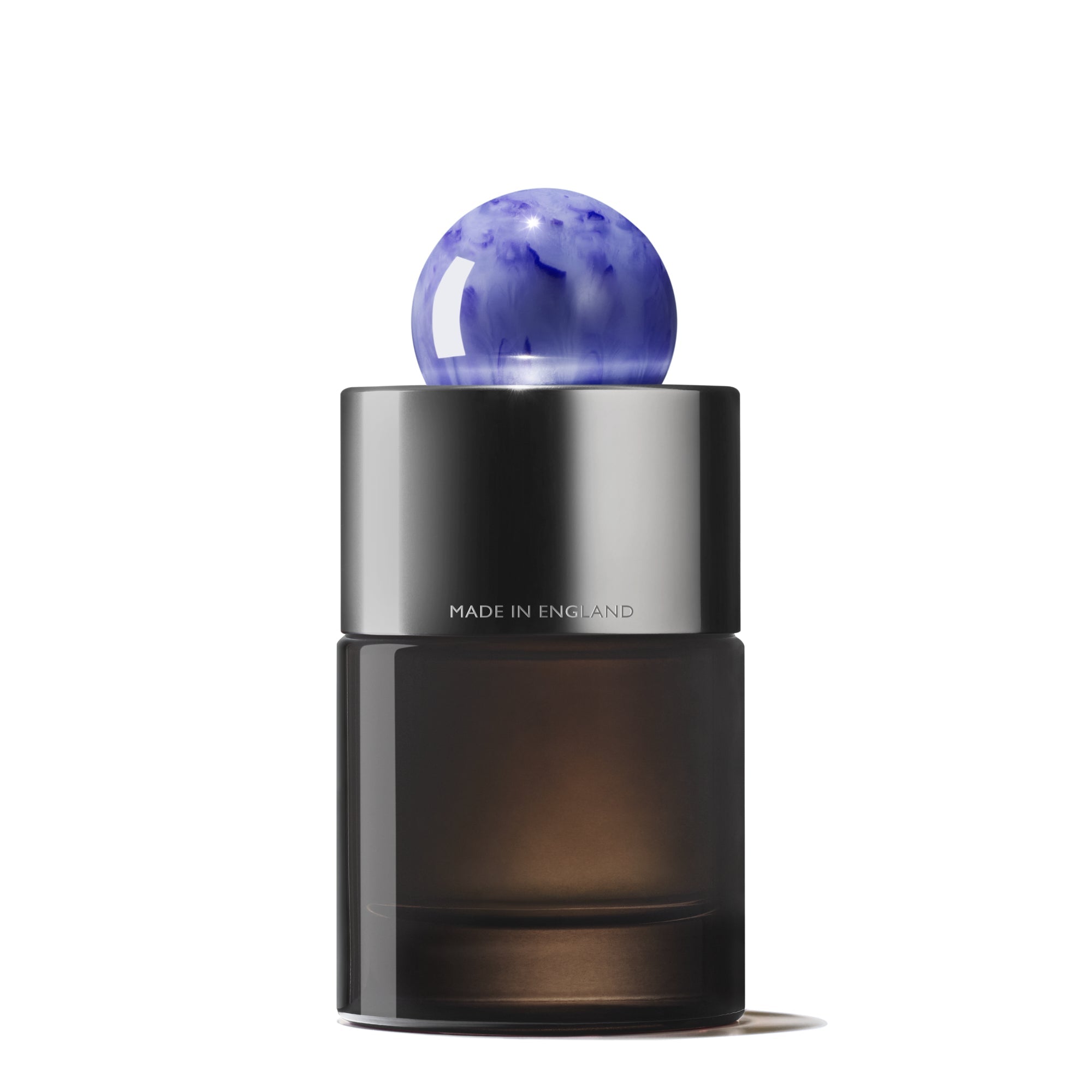 The MoltonBrown Cyprus Bluebell & Wild Strawberry Eau de Parfum, 100ml, features a sleek black cylindrical bottle with a marbled blue cap. Text reads MADE IN ENGLAND, hinting at its floral-fruity fragrance with notes of wild strawberry and violet leaf absolute.