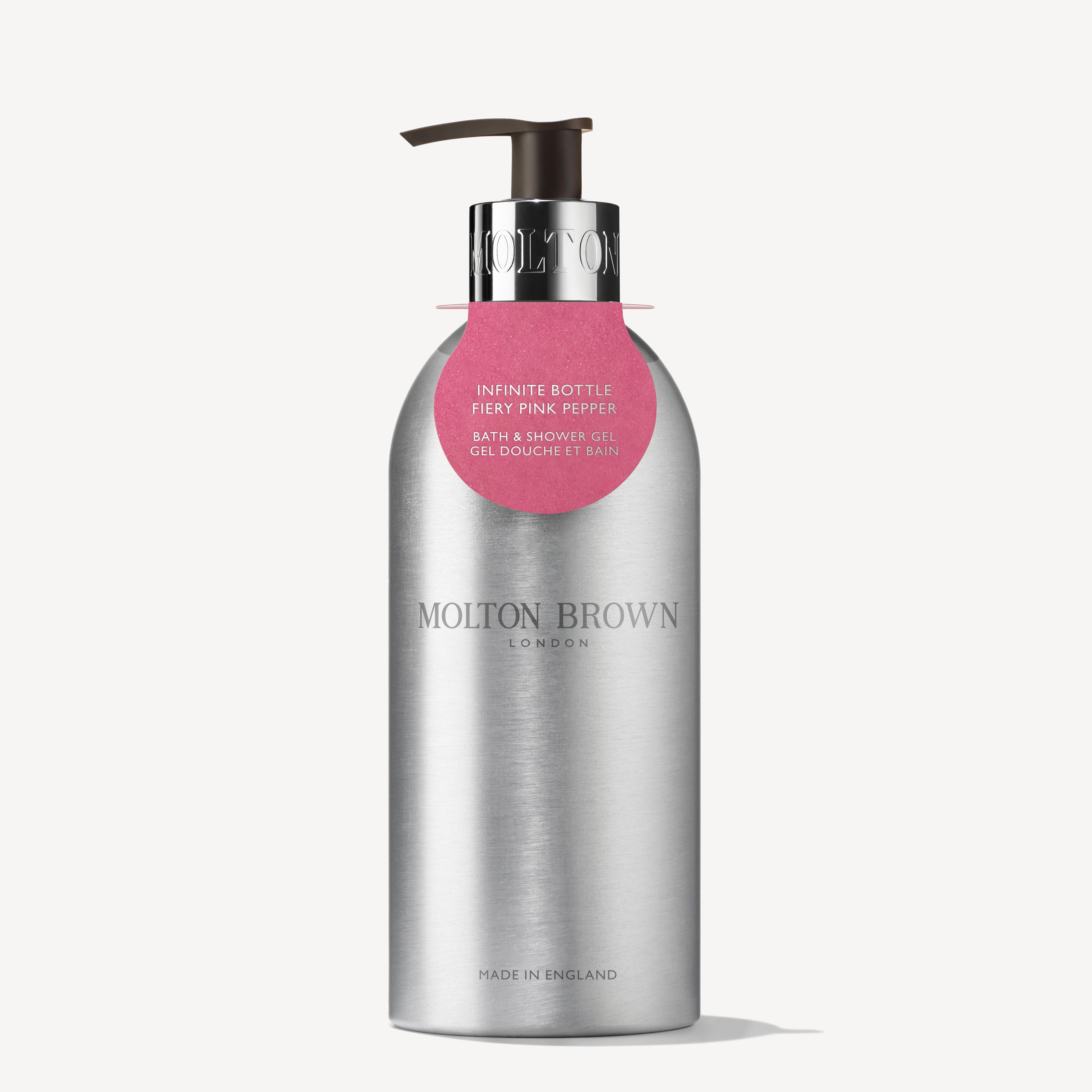 MoltonBrown Cyprus presents the Fiery Pink Pepper Infinite Bottle 400ml, a sleek silver pump bottle crafted from recycled aluminum. This woody-spicy body wash features a minimalist design with a small pink label and is a sustainable choice made in England.