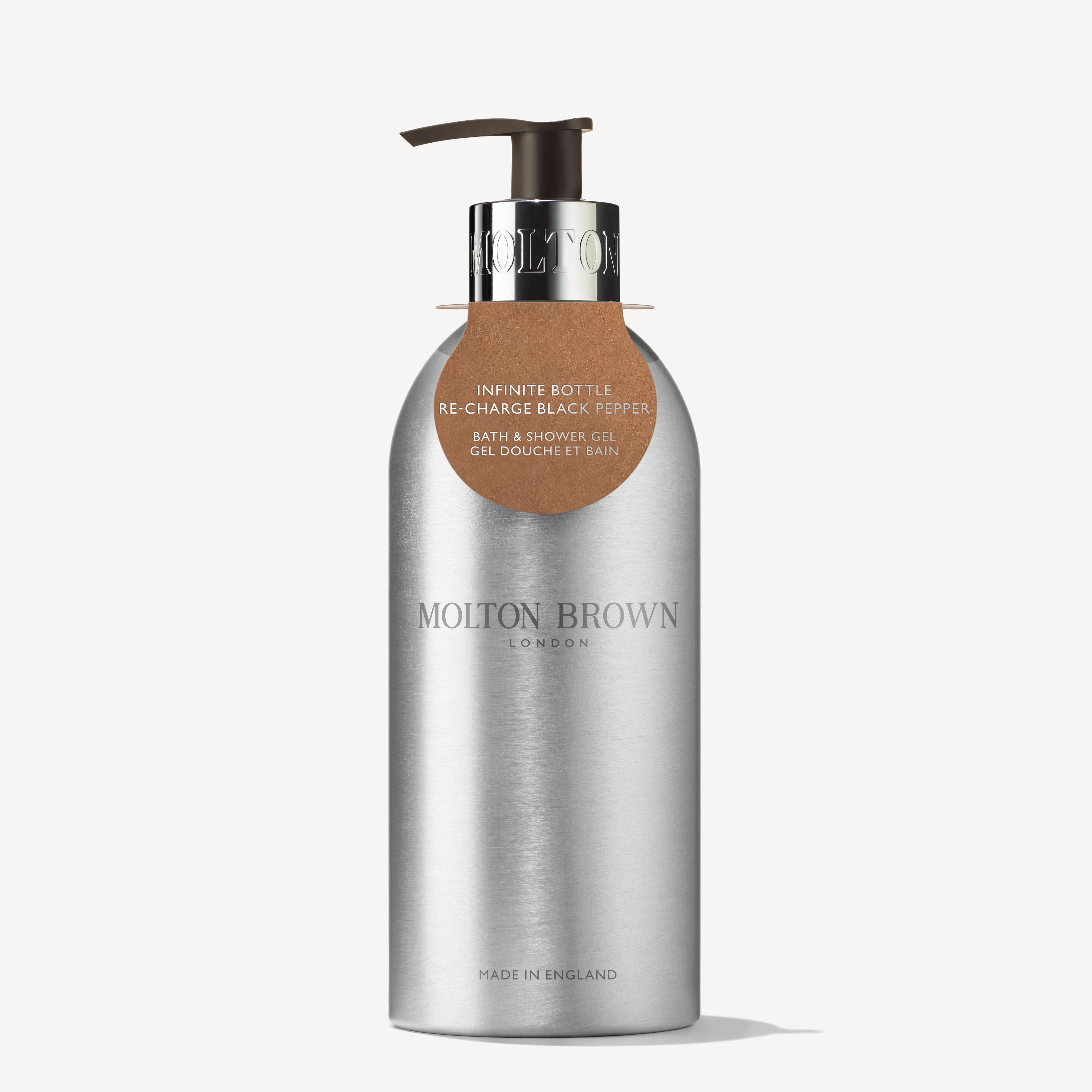 The Re-charge Black Pepper Infinite Bottle 400ml from MoltonBrown Cyprus is a sleek container crafted from recycled aluminum. Featuring a silver finish and a metal pump, it dispenses the woody-citrus blend of Re-charge Black Pepper bath and shower gel. The label, presented in both English and French, emphasizes its aromatic qualities. Proudly made in England, it pairs perfectly with a waste-reducing refill pouch.