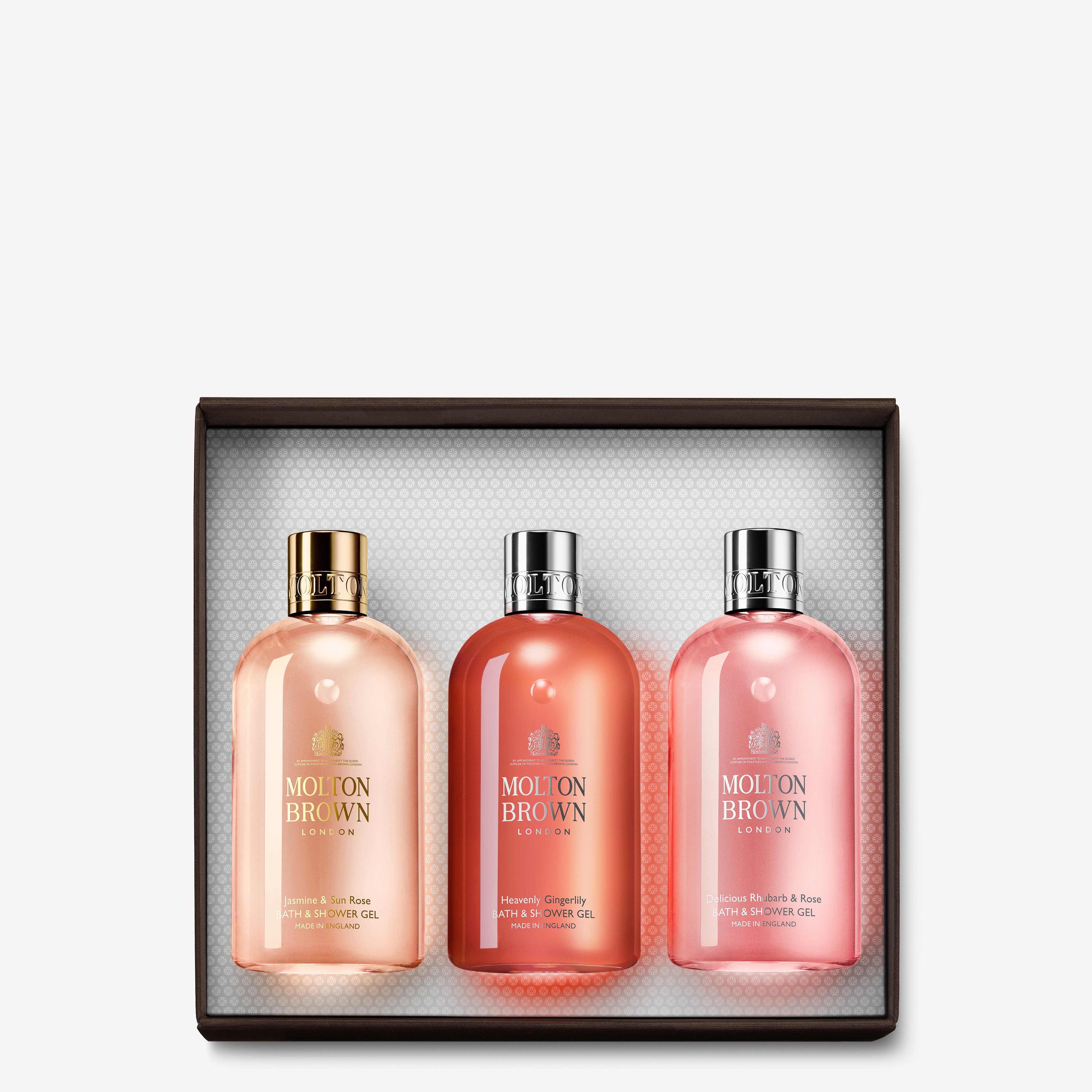 The Floral & Fruity Bathing Gift Set by MoltonBrown Cyprus showcases three Bath & Shower Gels in a pink-themed packaging, with the bottles elegantly displayed against a textured white background inside the gift box.