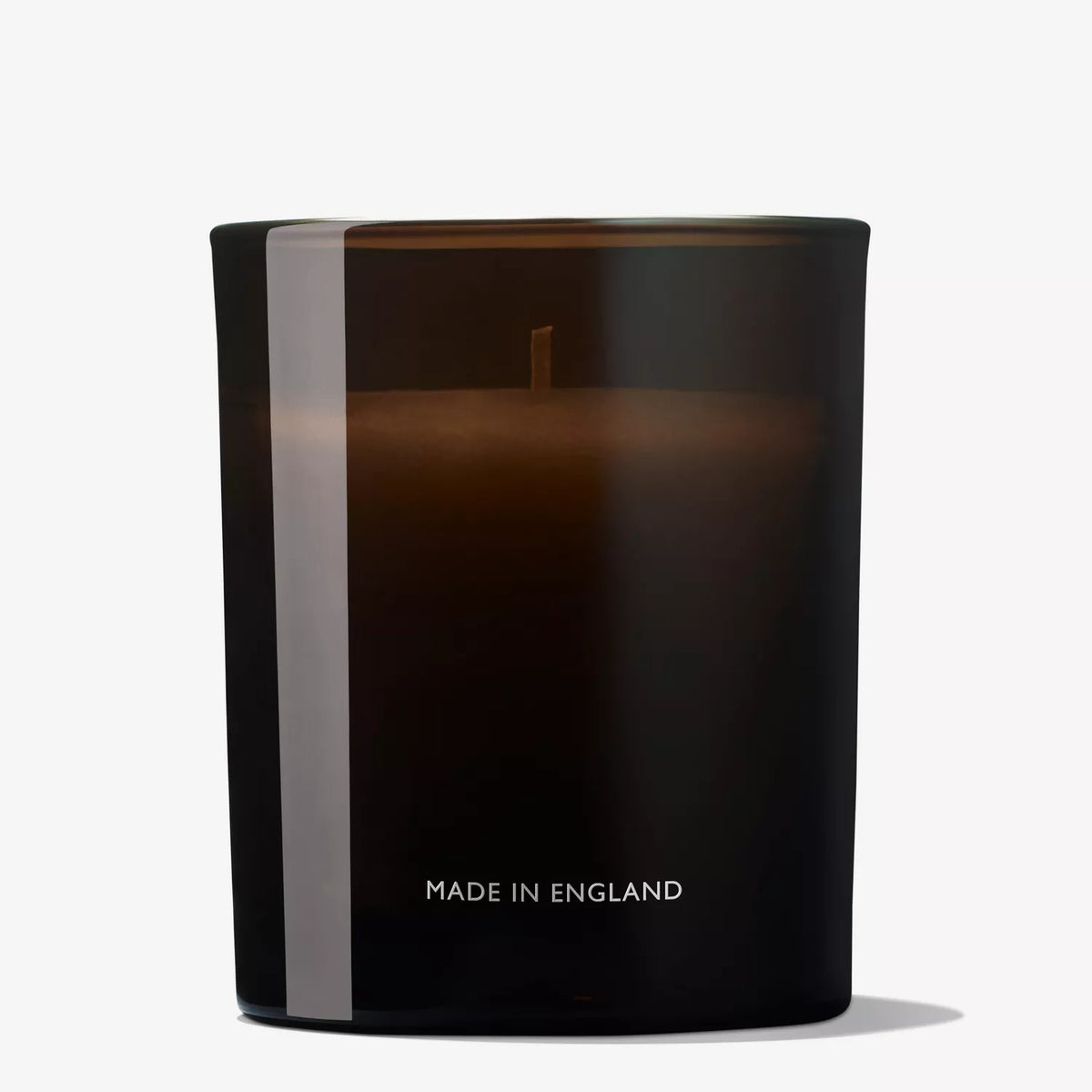 The Mesmerising Oudh Accord & Gold Signature Candle 190g by MoltonBrown Cyprus showcases a sleek black jar with a minimalist design. A single wick enhances the opulent scent of cinnamon, while bold white MADE IN ENGLAND lettering adds understated elegance.