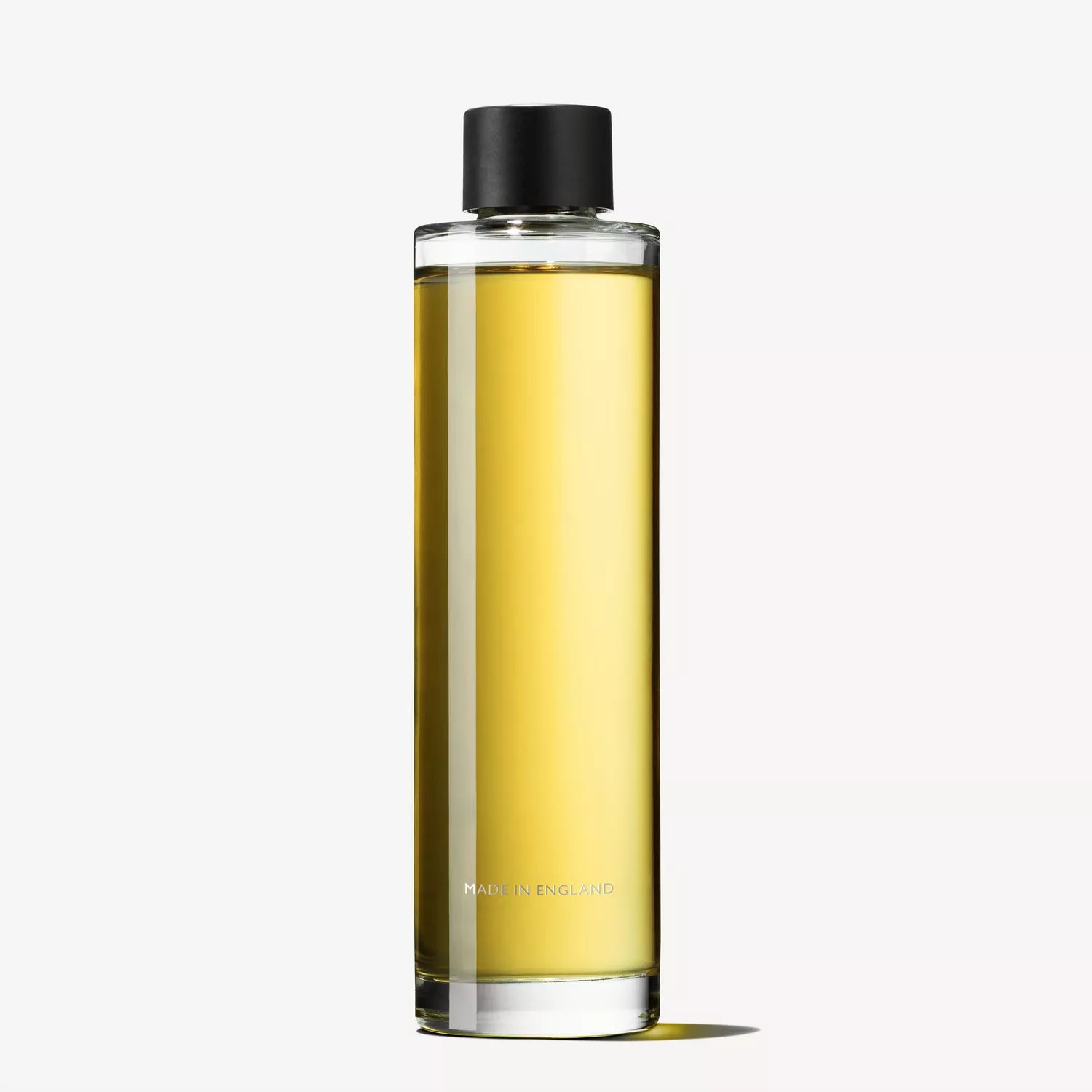 A sophisticated MoltonBrown Cyprus perfume bottle, Sample 3, exemplifies elegance with its tall cylindrical shape and golden liquid. The design is sleek and minimalist, featuring a black cap. "Made in England" is printed discreetly on the lower portion, all presented against a plain white background.