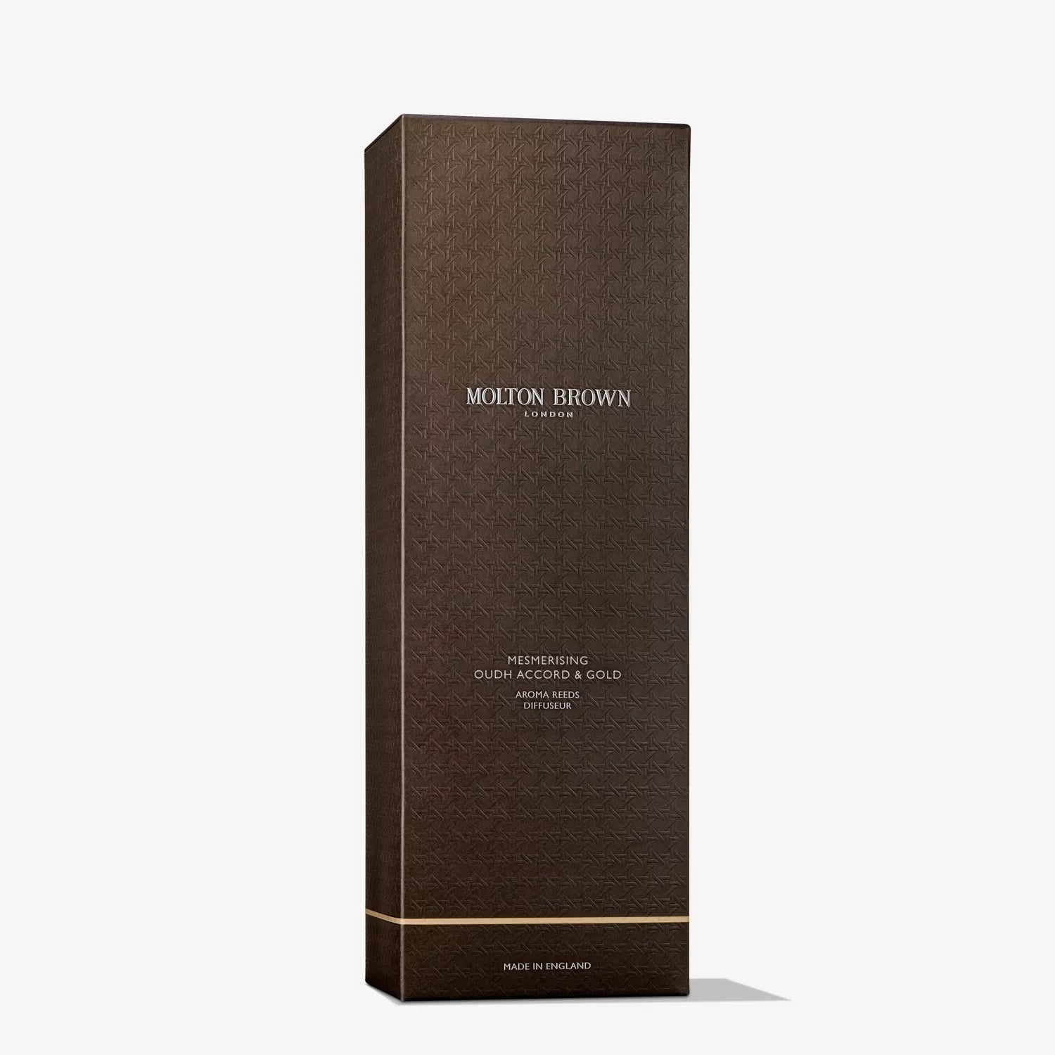 A tall, dark brown box with a gold-accented design labeled Mesmerising Oudh Accord & Gold Aroma Reeds 150ml by MoltonBrown Cyprus offers a touch of scented decadence.