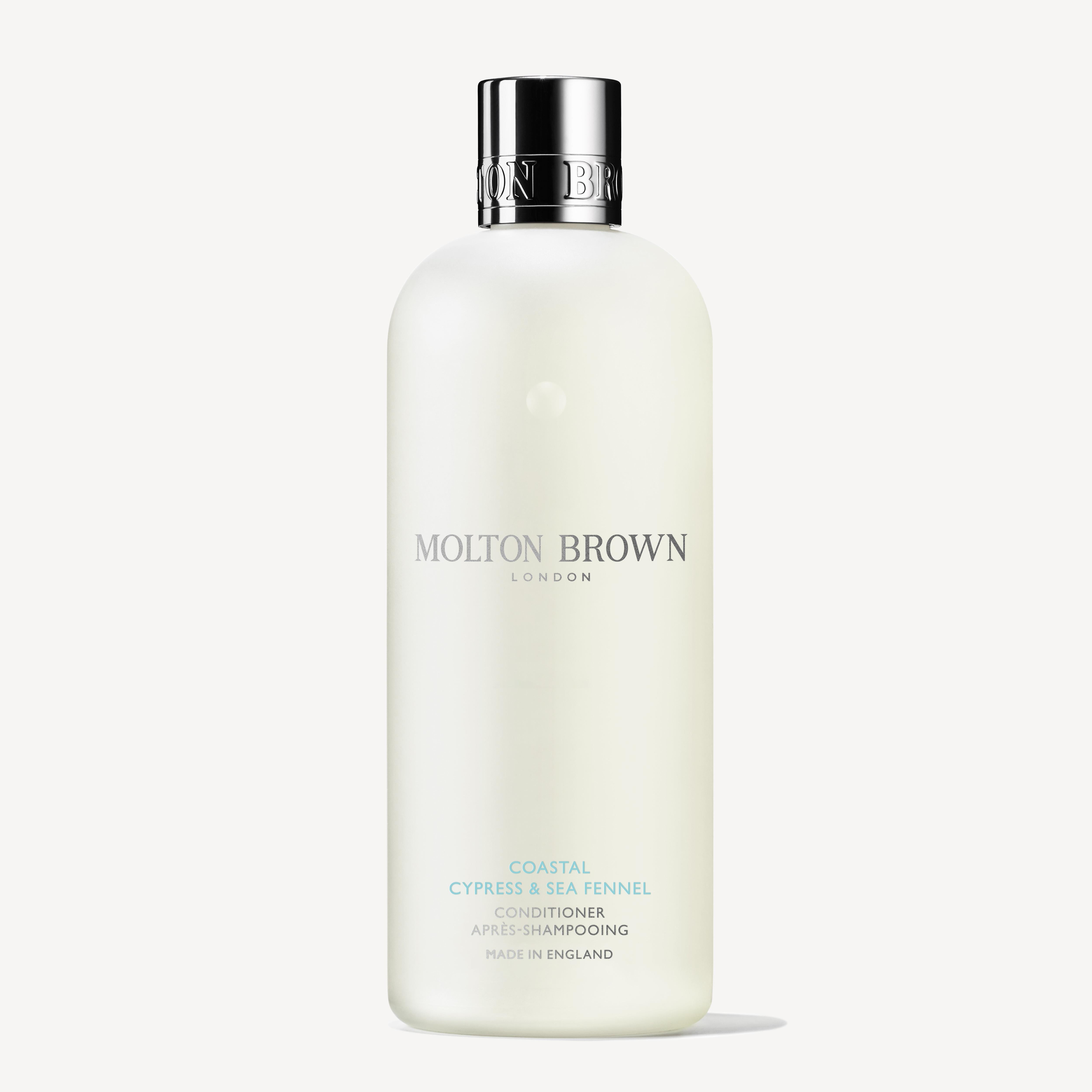A 300ml bottle of Molton Brown Cyprus Coastal Cypress & Sea Fennel Conditioner stands upright with a silver cap and minimalist white label, set against a white background—ideal for all hair types.