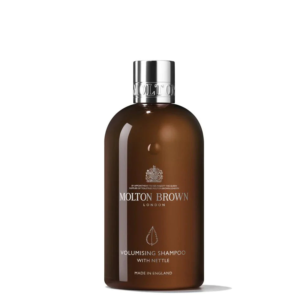 A 300ml brown bottle of MoltonBrown Cyprus Volumising Shampoo with Nettle features a chrome cap and LONDON and MADE IN ENGLAND in white text on the front, set against a plain white background.