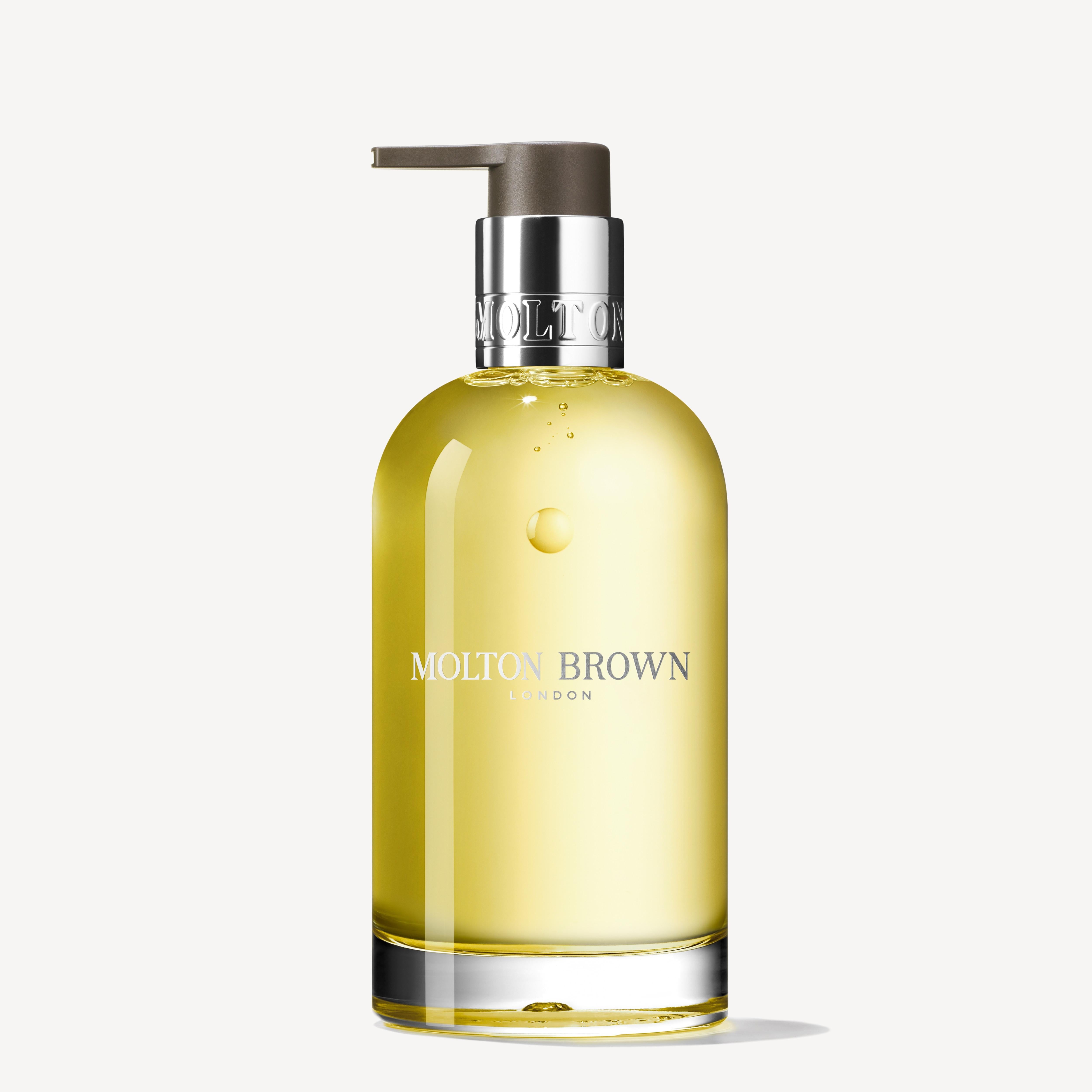 A sleek, minimalist clear glass bottle with a silver pump holds the refreshing Molton Brown Cyprus Orange & Bergamot Fine Liquid Hand Wash 200ml.